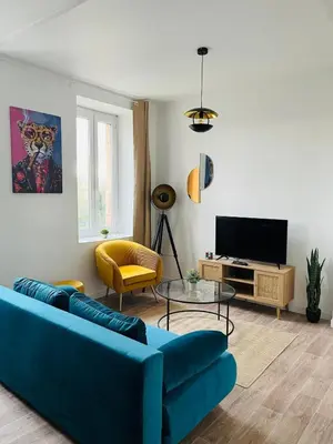 a living room with a blue couch and a tv at L'atypique l 2 chambres l Clim in Castres