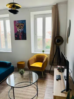 a living room with a blue couch and a glass table at L'atypique l 2 chambres l Clim in Castres