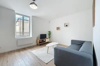 a living room with a blue couch and a window at Bright 1-bedroom apartment in Cuxac-dʼAude