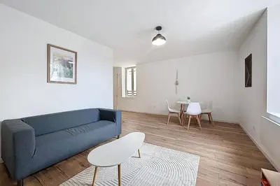a living room with a blue couch and a table at Bright 1-bedroom apartment in Cuxac-dʼAude