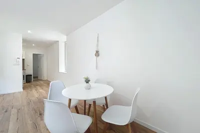 a white dining room with a white table and chairs at Bright 1-bedroom apartment in Cuxac-dʼAude
