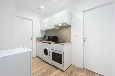 a kitchen with a washer and dryer next to a door at Bright 1-bedroom apartment in Cuxac-dʼAude