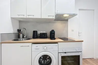 a kitchen with a washing machine and a sink at Bright 1-bedroom apartment in Cuxac-dʼAude