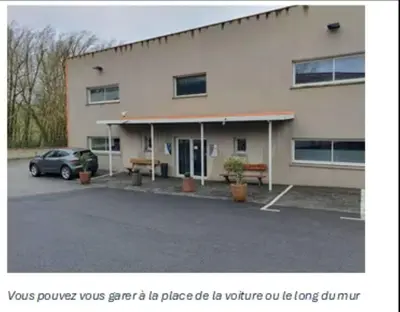 a building with a car parked in a parking lot at la tanière argentée in Nailloux