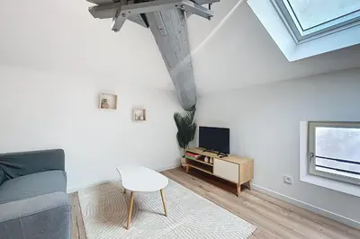 a white living room with a couch and a chair at Spacious studio for two in Cuxac-d'Aude in Cuxac-dʼAude