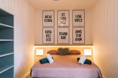 a bedroom with a bed with four pictures on the wall at Magnifique T3-terrasse-parking-Centre ville-AD in Carcassonne
