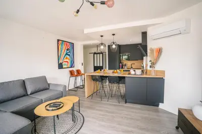 a living room and kitchen with a couch and a table at Magnifique T3-terrasse-parking-Centre ville-AD in Carcassonne