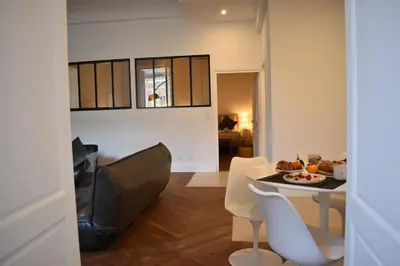 a living room with a couch and a table and chairs at L'Opaline in Carcassonne