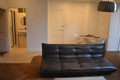 a black leather couch in a living room with a table at L'Opaline in Carcassonne