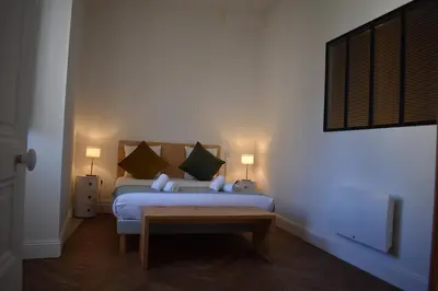 a bedroom with a bed with pillows and two lamps at L'Opaline in Carcassonne
