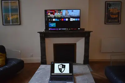 a laptop sitting on a table in a living room with a fireplace at L'Opaline in Carcassonne