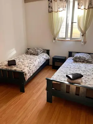 a bedroom with two beds and a window at Charmante Maison de Village avec Terrasse in Olonzac