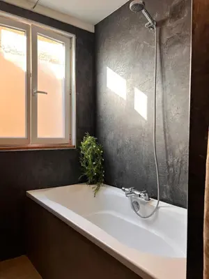 a bathroom with a bath tub with a shower at Charmante Maison de Village avec Terrasse in Olonzac