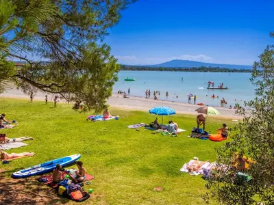 a group of people laying on the grass at a beach at Charmante Maison de Village avec Terrasse in Olonzac