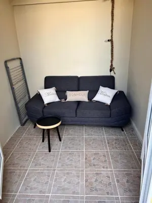 a living room with a blue couch and a table at Charmante Maison de Village avec Terrasse in Olonzac