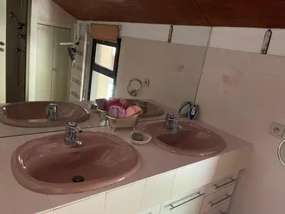 a bathroom with two sinks and a mirror at Aux portes du Sidobre in Burlats