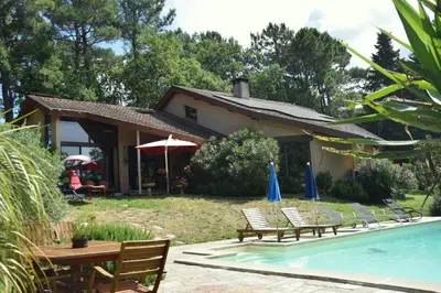 a house with a pool and some chairs and a table at Aux portes du Sidobre in Burlats