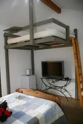 a bedroom with a bunk bed and a tv at Aux portes du Sidobre in Burlats