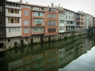 a row of buildings next to a body of water at La maison au bout de l'allée in Carbes