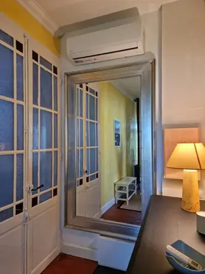 a room with a mirror and a desk with a lamp at Le charme à la française - Appartement 4 pers in La Redorte