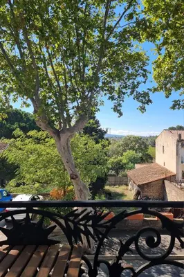 a bench sitting in front of a tree at Le charme à la française - Appartement 4 pers in La Redorte