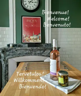 a bottle of whiskey on a table with a clock at Le charme à la française - Appartement 4 pers in La Redorte