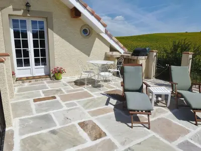 a patio with chairs and a table in front of a house at Charming cottage style property nestled in stunning French countryside near Carcassonne and Mirepoix in Hounoux