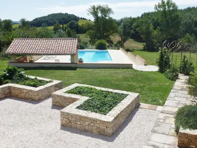 a backyard with a swimming pool and a stone wall at Charming cottage style property nestled in stunning French countryside near Carcassonne and Mirepoix in Hounoux
