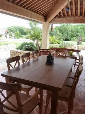 a wooden table and chairs on a patio at Charming cottage style property nestled in stunning French countryside near Carcassonne and Mirepoix in Hounoux