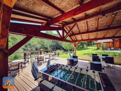 a log cabin with a large porch in the grass at Camping 2 étoiles - Piscine - ccb0hef in Fenouillet