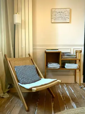a room with a chair and a shelf with books at 19Th Century Mansion With Pool Near Castres in Payrin-Augmontel