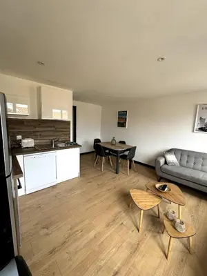 a living room with a couch and a table at Beau T3 coeur village in Gruissan