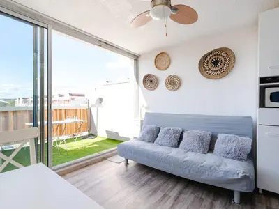 a living room with a couch and a large window at Studio cabine avec terrasse, animaux admis, pour 4 personnes - FR-1-409A-33 in Gruissan