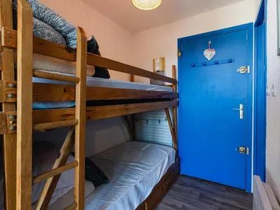 a bunk bed room with two bunk beds and a blue door at Studio cabine avec terrasse, animaux admis, pour 4 personnes - FR-1-409A-33 in Gruissan
