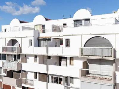 a white apartment building with balconies on it at Studio cabine avec terrasse, animaux admis, pour 4 personnes - FR-1-409A-33 in Gruissan