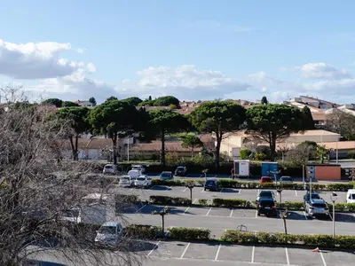 a parking lot with parked cars in a city at Studio cabine avec terrasse, animaux admis, pour 4 personnes - FR-1-409A-33 in Gruissan
