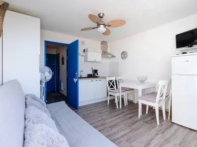 a living room with a kitchen and a dining table at Studio cabine avec terrasse, animaux admis, pour 4 personnes - FR-1-409A-33 in Gruissan