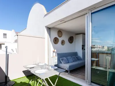 a patio with a couch and a table on a balcony at Studio cabine avec terrasse, animaux admis, pour 4 personnes - FR-1-409A-33 in Gruissan