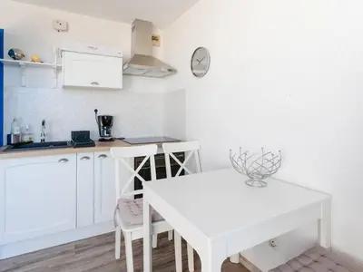 a kitchen with a white table and a white counter top at Studio cabine avec terrasse, animaux admis, pour 4 personnes - FR-1-409A-33 in Gruissan