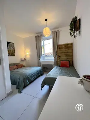 a bedroom with two beds and a window at L'abeille in Durban-Corbières
