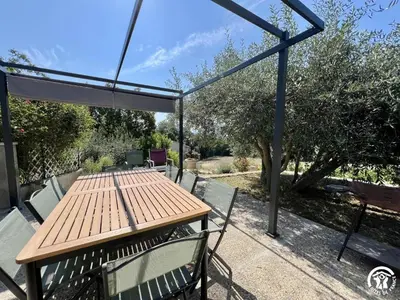 a picnic table and chairs under a canopy at Peyret in Cépie