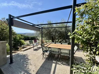a patio with a wooden table and chairs at Peyret in Cépie