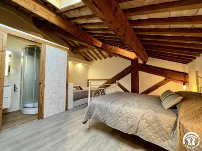 a bedroom with a bed in a room with wooden ceilings at La ruche in Durban-Corbières