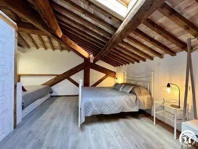 a bedroom with two beds in a room with wooden ceilings at La ruche in Durban-Corbières