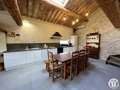 a kitchen with a wooden table and chairs at La ruche in Durban-Corbières