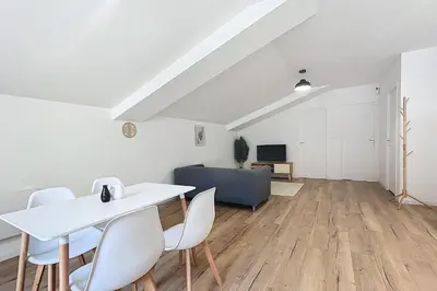 a living room with a white table and chairs at T3 apartment in the heart of Cuxac-d'Aude in Cuxac-dʼAude