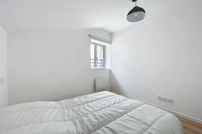 a white room with a bed and a window at T3 apartment in the heart of Cuxac-d'Aude in Cuxac-dʼAude