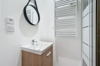 a bathroom with a sink and a mirror at T3 apartment in the heart of Cuxac-d'Aude in Cuxac-dʼAude