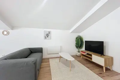 a living room with a couch and a tv at T3 apartment in the heart of Cuxac-d'Aude in Cuxac-dʼAude