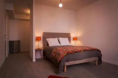 a bedroom with a bed with two pillows and two lamps at La PARERIE 2 in Carcassonne